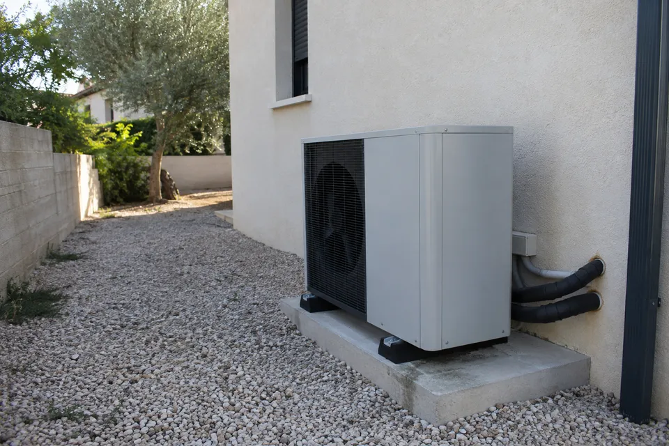 Bomba de calor aire-agua con tuberías aisladas junto a una vivienda Bomba de calor aire-agua con tuberías aisladas junto a una vivienda