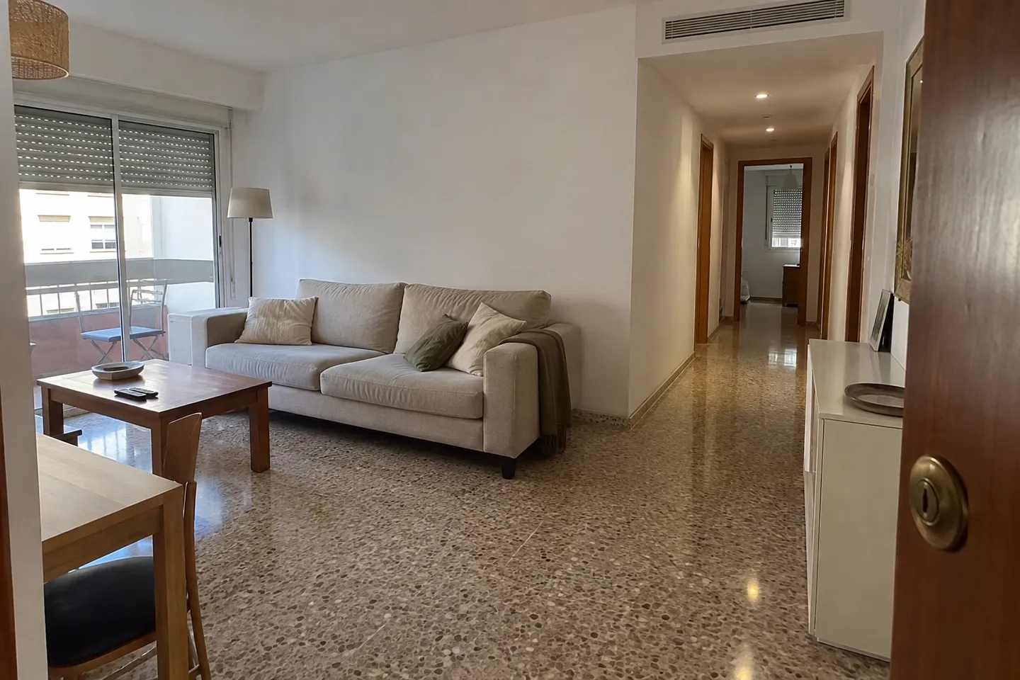 Salón comunicado con un pasillo y rejilla de climatización integrada en el techo Salón comunicado con un pasillo y rejilla de climatización integrada en el techo